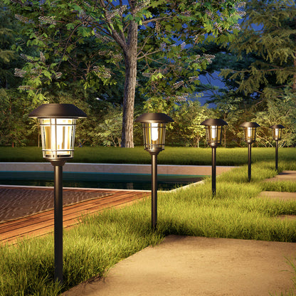 Outdoor garden lights illuminating a pathway next to a pool at night.