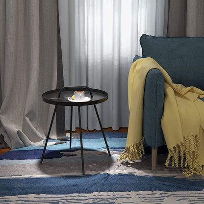 Living room with a blue sofa, yellow blanket, and a small round table.