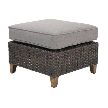 Wicker ottoman with a gray cushion on a white background