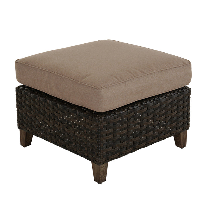 Brown wicker ottoman with a cushion on a white background