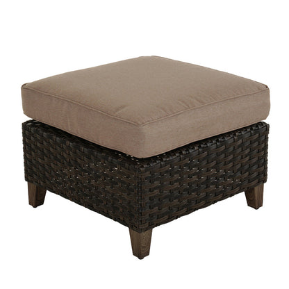 Brown wicker ottoman with a cushion on a white background