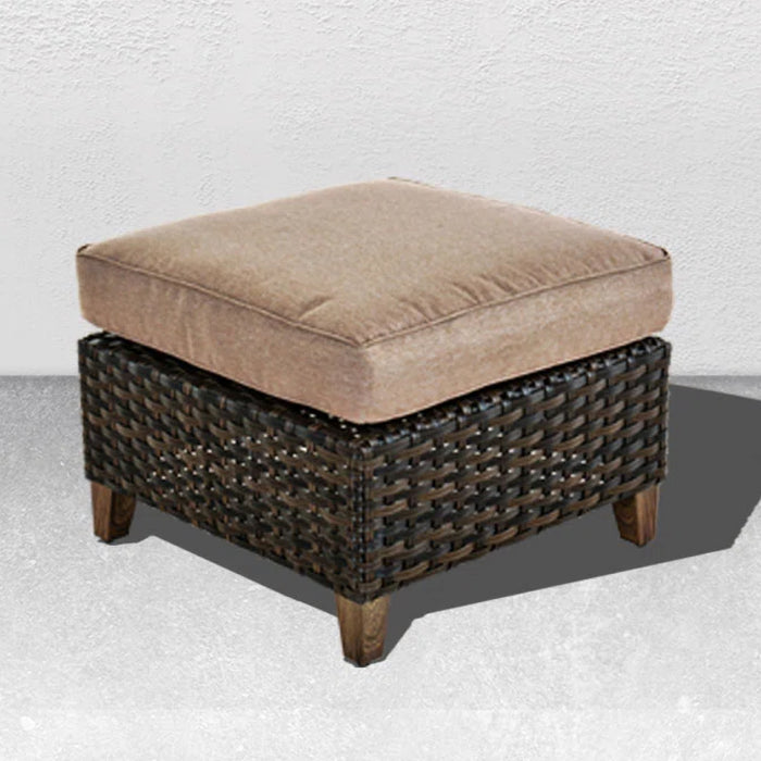 Wicker ottoman with a cushion on a textured white background