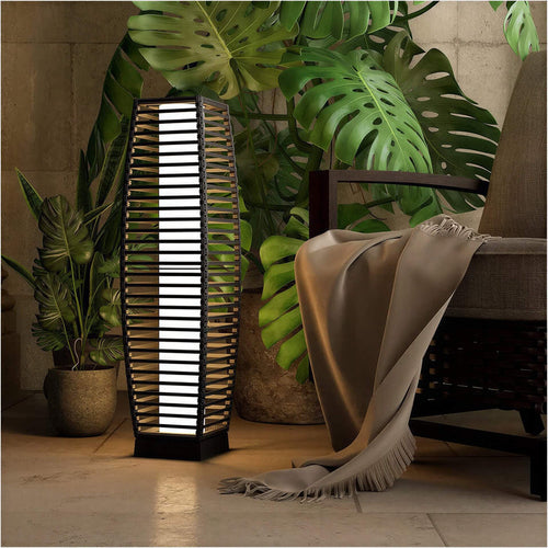 Grand Patio outdoor solar-powered crossover woven resin wicker floor lamp beside a chair and plants in a cozy setting.