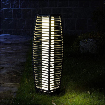 Grand Patio outdoor solar-powered crossover woven resin wicker floor lamp with a tall, textured design illuminated at night.