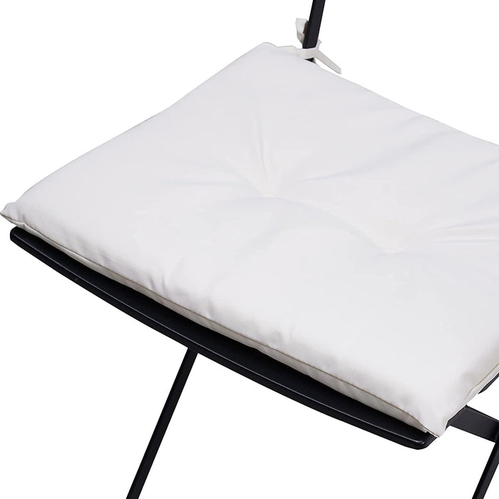 White pillow on a black chair with a white background